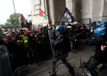 Los manifestantes chocan con la policía antidisturbios en una estación de tren.