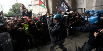 Los manifestantes chocan con la policía antidisturbios en una estación de tren.