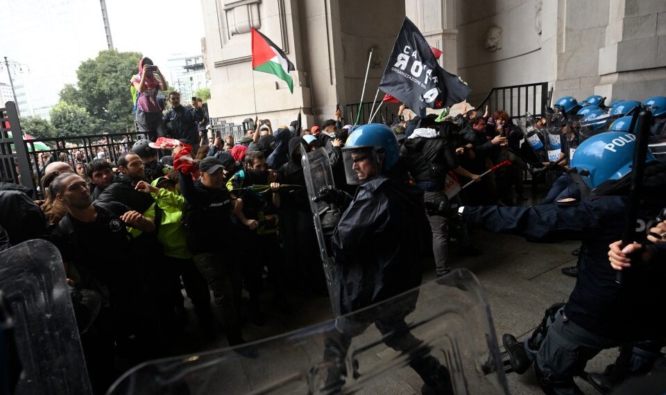 Los manifestantes chocan con la policía antidisturbios en una estación de tren.