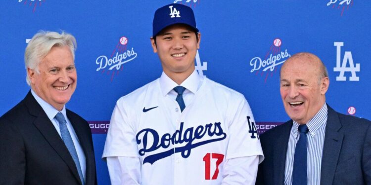 El jugador de béisbol japonés Shohei Ohtani (C) se posa con Mark Walter (L), propietario de Los Angeles Dodgers, y Andrew Friedman (R), presidente de operaciones de béisbol de los Dodgers de Los Ángeles de Los Ángeles en Los Angeles de Los Ángeles en Los Angeles en los Angeles.
