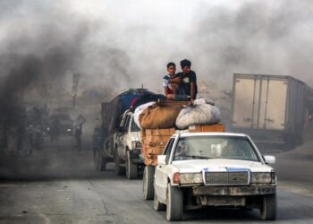 Los jóvenes montan en los paquetes y muebles en un carro remolcado por otro vehículo mientras las personas evacúan hacia el sur desde la ciudad de Gaza el 2 de septiembre de 2025. (Eyad Baba/AFP a través de Getty Images)