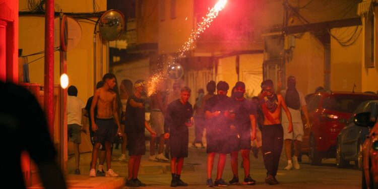 Los manifestantes se enfrentan con la policía por la noche.