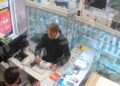 Las imágenes de CCTV muestran a un hombre con una sudadera con capucha negra que compraba un teléfono en un mostrador en una tienda.