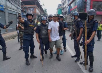 Oficiales de policía escoltando a un prisionero.