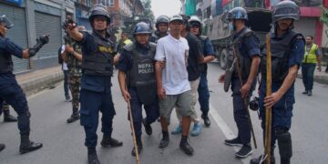 Oficiales de policía escoltando a un prisionero.