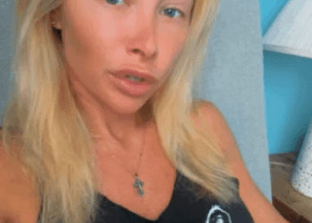 Ganna usando una camiseta sin mangas negra con un gato en diseño de gafas de sol.