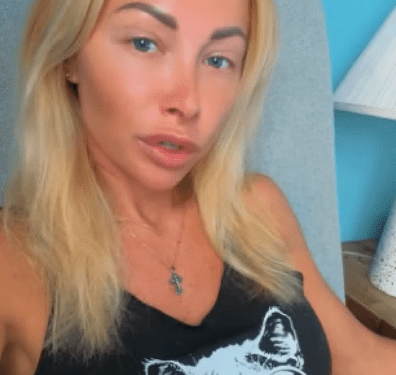 Ganna usando una camiseta sin mangas negra con un gato en diseño de gafas de sol.