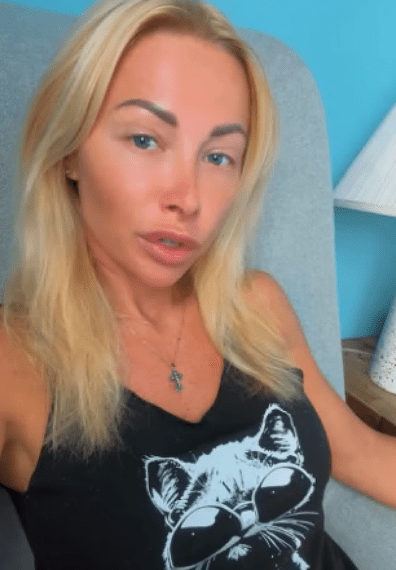 Ganna usando una camiseta sin mangas negra con un gato en diseño de gafas de sol.