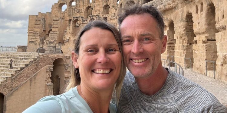 Lindsay y Craig Foreman sonriendo frente a las antiguas ruinas.