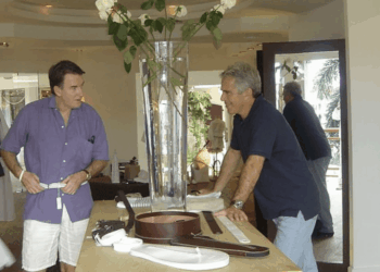 Dos hombres mirando los cinturones en una tienda.
