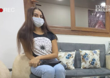 Shamima Begum con una mascarilla y una camiseta con un diseño del zodiaco, sentado en un sofá durante una entrevista.