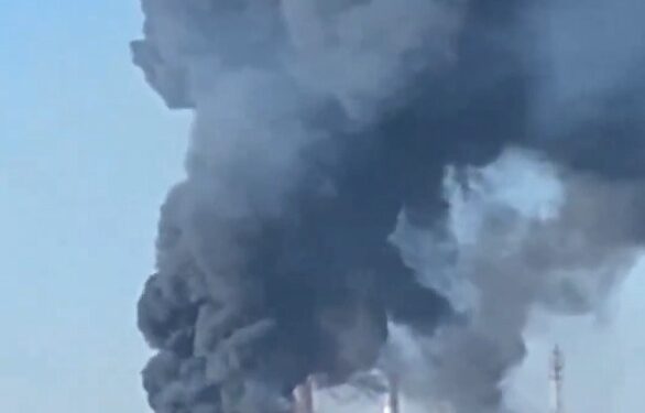 Grandes columnas de humo negro y fuego se elevan de una planta industrial.
