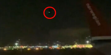 La luz verde rodeó en rojo en el cielo nocturno.