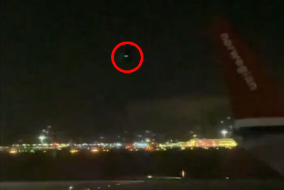 La luz verde rodeó en rojo en el cielo nocturno.