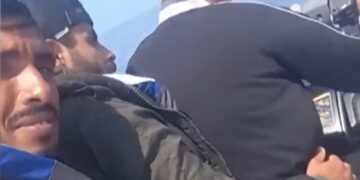 Hombres en un bote mirando el agua.