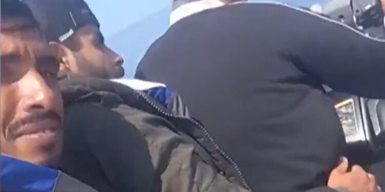 Hombres en un bote mirando el agua.