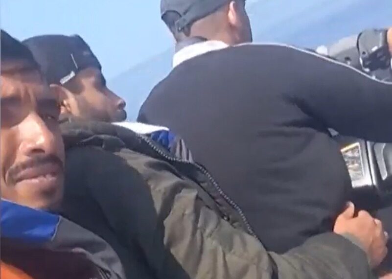 Hombres en un bote mirando el agua.