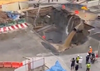 Sin embargo, se sumerge en una concurrida calle Bangkok con agua de color de barro que se vierte de una pipa y la gente observa.