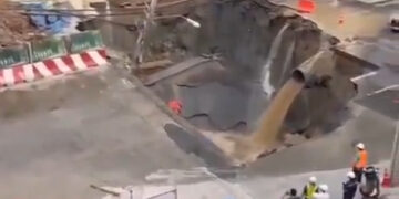 Sin embargo, se sumerge en una concurrida calle Bangkok con agua de color de barro que se vierte de una pipa y la gente observa.