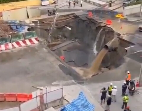 Sin embargo, se sumerge en una concurrida calle Bangkok con agua de color de barro que se vierte de una pipa y la gente observa.