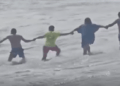 Cadena humana rescatando a un niño de fuertes corrientes.
