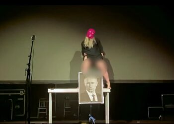 El activista antidisturbios de coño Anastasia 'Taso' Pletner orina en un retrato de Vladimir Putin.