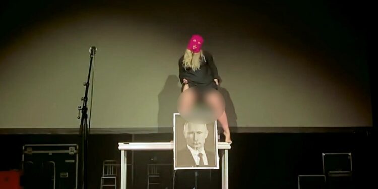 El activista antidisturbios de coño Anastasia 'Taso' Pletner orina en un retrato de Vladimir Putin.