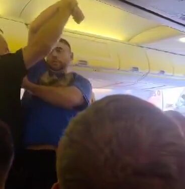 Los oficiales de policía retiran a un pasajero disruptivo de un avión.