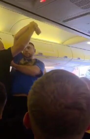 Los oficiales de policía retiran a un pasajero disruptivo de un avión.