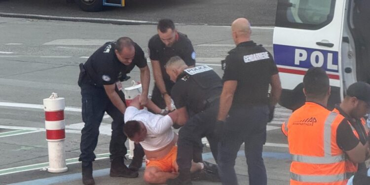 Oficiales de policía que arrestaron a un hombre en un aeropuerto.