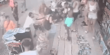 Imágenes de seguridad de una pelea en una multitud de personas.