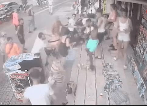 Imágenes de seguridad de una pelea en una multitud de personas.