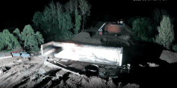 Las imágenes de CCTV de un automóvil se estrellan contra un pilar de soporte de puente, se incendian y caen en un río.