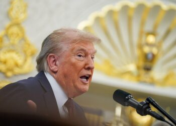 El presidente Trump hablando en un podio en la Oficina Oval.