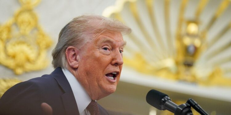 El presidente Trump hablando en un podio en la Oficina Oval.