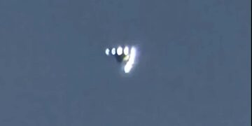 OVNI en forma de V con luces flotantes en el cielo.