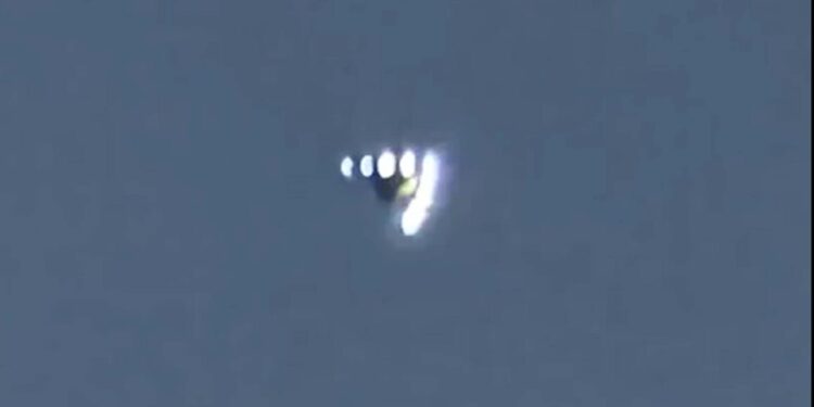 OVNI en forma de V con luces flotantes en el cielo.