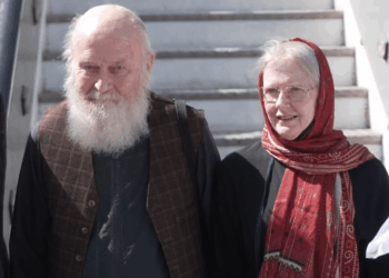 Un hombre calvo con barba blanca y una mujer con un pañuelo rojo.
