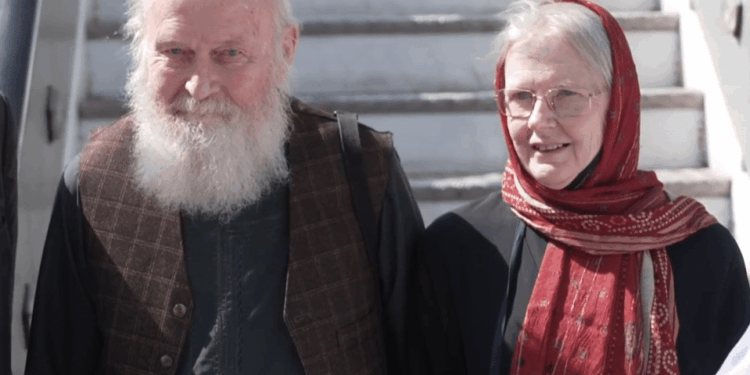 Un hombre calvo con barba blanca y una mujer con un pañuelo rojo.