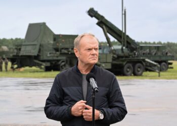 El primer ministro Donald Tusk habla en un podio frente a los vehículos militares durante el ejercicio de entrenamiento 'Autumn Fire-25'.