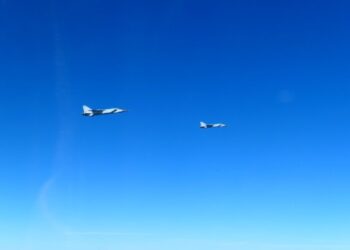 Dos aviones de combate MIG-31 rusos volando en cielos azules claros.