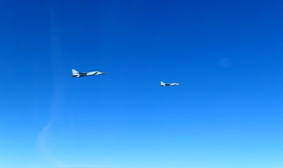 Dos aviones de combate MIG-31 rusos volando en cielos azules claros.