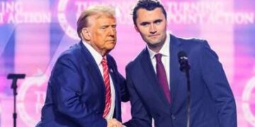 El activista de derecha Charlie Kirk habla en el escenario con Donald Trump en America Fest 2024 en Phoenix, Arizona, el 22 de diciembre de 2024.
