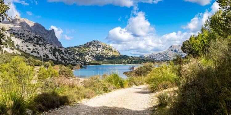 Camino que conduce a un lago rodeado de montañas.