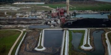 Los dos estanques de cenizas sin frases se ven en primer plano de la estación generadora de carbón NRG Waukegan en Waukegan.