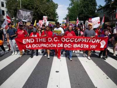 Los manifestantes tienen un banner mientras participan en el "Todos somos DC" Marcha nacional en solidaridad con las comunidades de DC y pidiendo el fin del despliegue de tropas de la Guardia Nacional en Washington, DC, el 6 de septiembre de 2025.