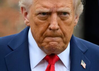 El presidente de los Estados Unidos, Donald Trump, con un traje azul y una corbata roja.