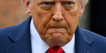 El presidente de los Estados Unidos, Donald Trump, con un traje azul y una corbata roja.