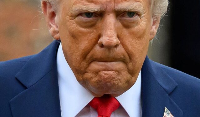 El presidente de los Estados Unidos, Donald Trump, con un traje azul y una corbata roja.