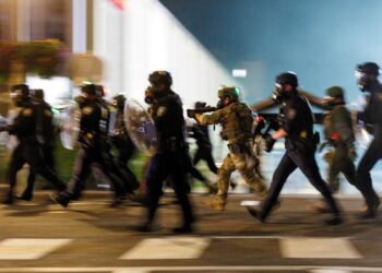 Los agentes de ICE cobran hacia manifestantes fuera de un centro de detención en Portland, Oregon.